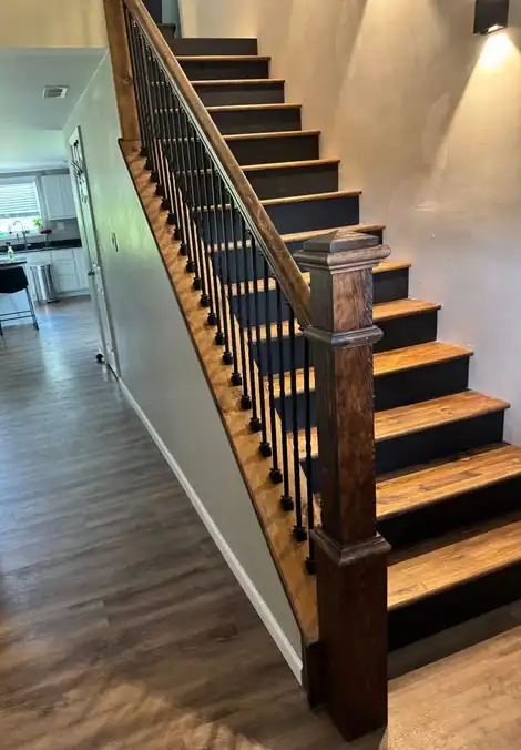 Finished staircase with dark balusters and wood treads