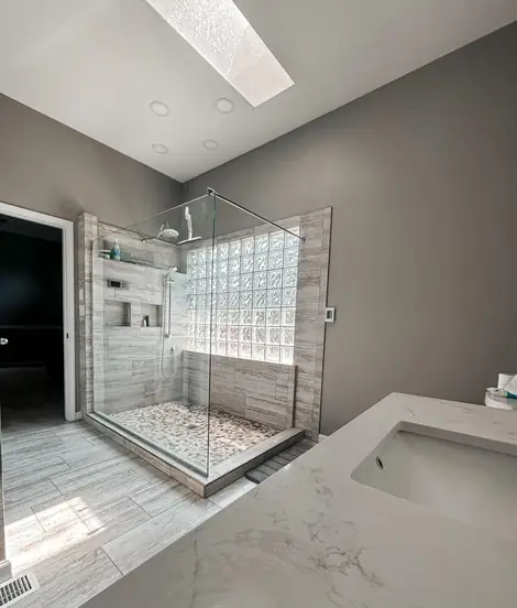 Finished walk-in shower with glass in a light bathroom